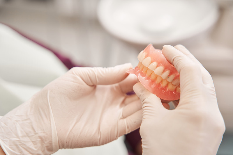 Dentist restoring damaged dentures